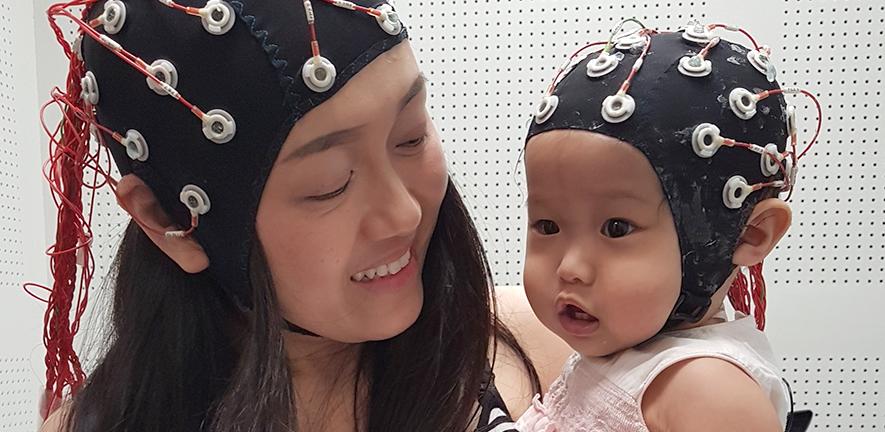 Woman with a child wearing dual electroencephalograhy on they heads