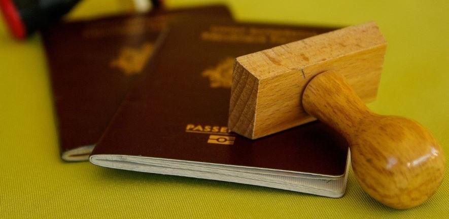 Two passports with a wooden stamp lying across them.